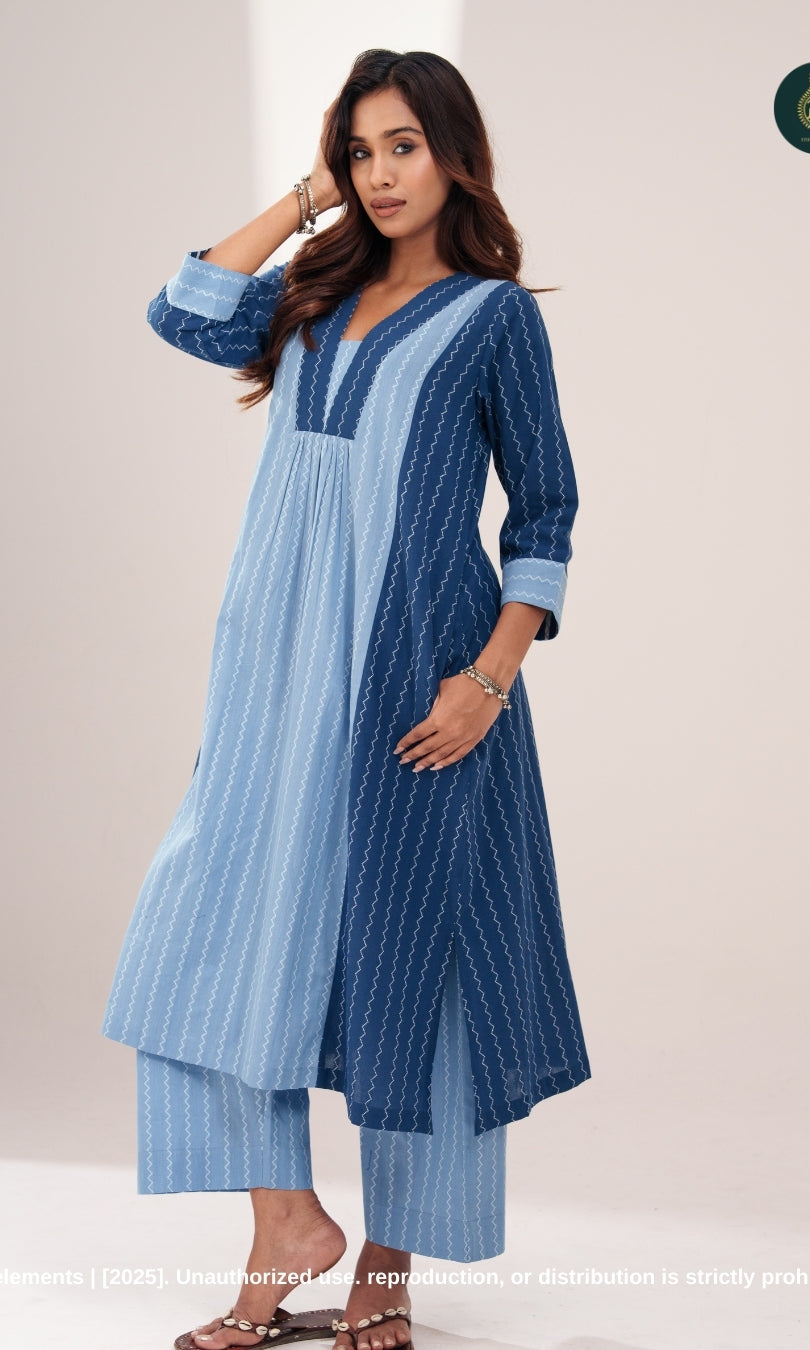 A woman modeling a dual-tone indigo cotton co-ord set with a sleeveless inner kurta and a flowy open-front jacket, paired with matching straight-fit pants.