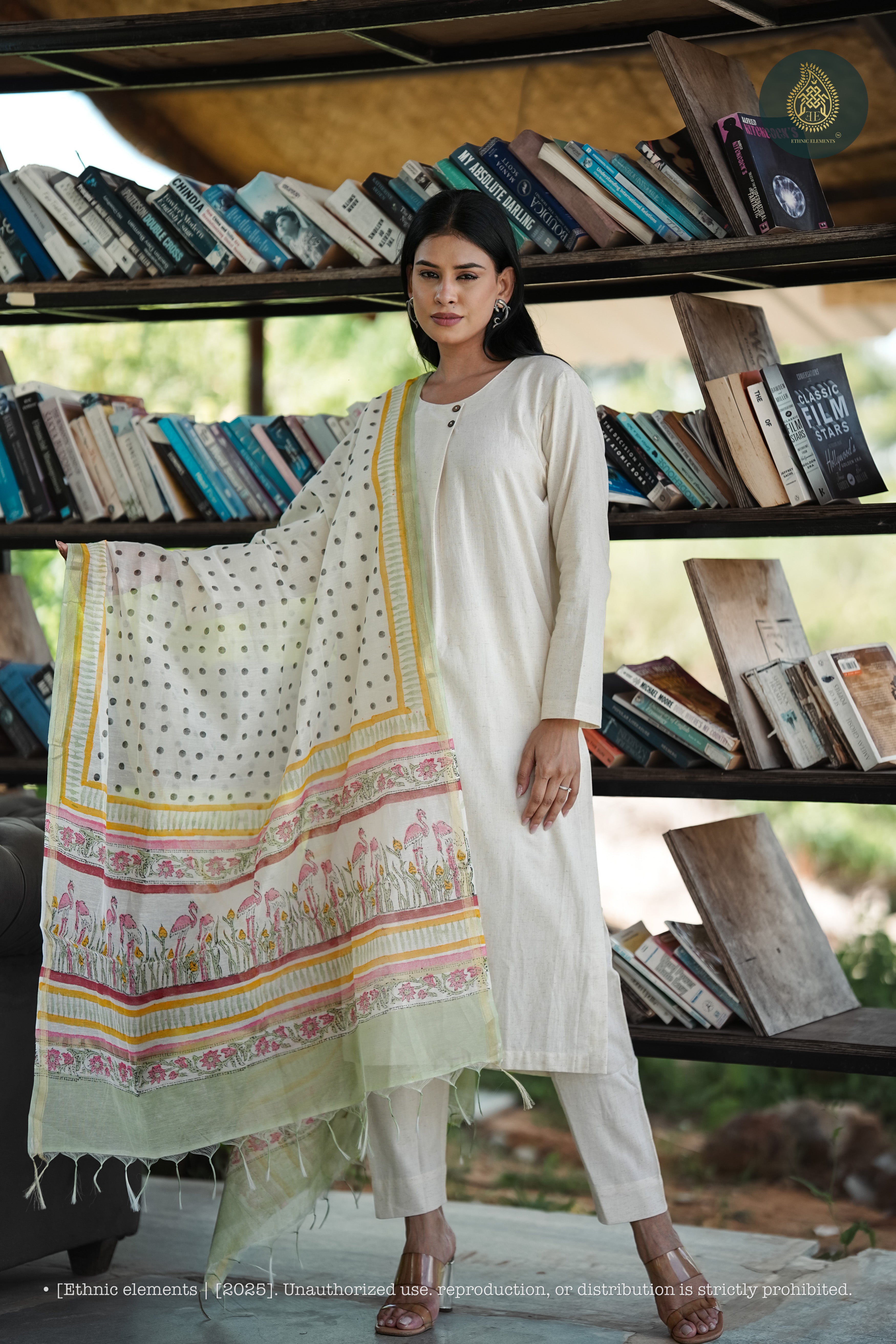 Woman holding a patterned scarf in front of bookshelves